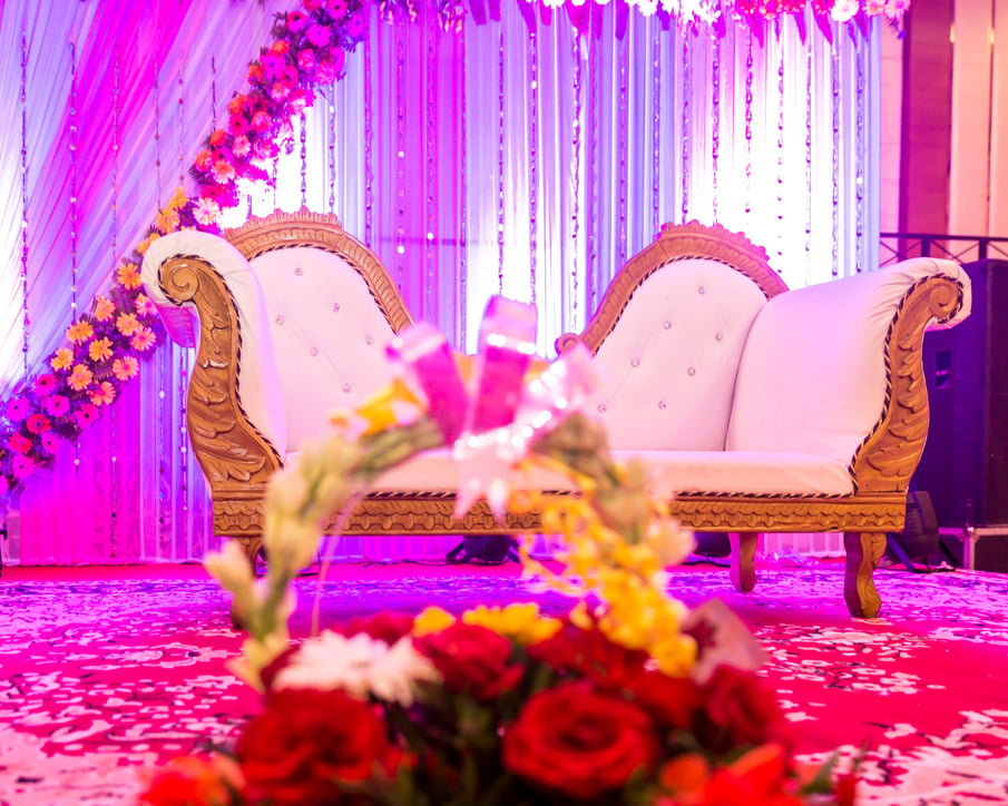 Indian wedding stage decorations with colorful flowers.