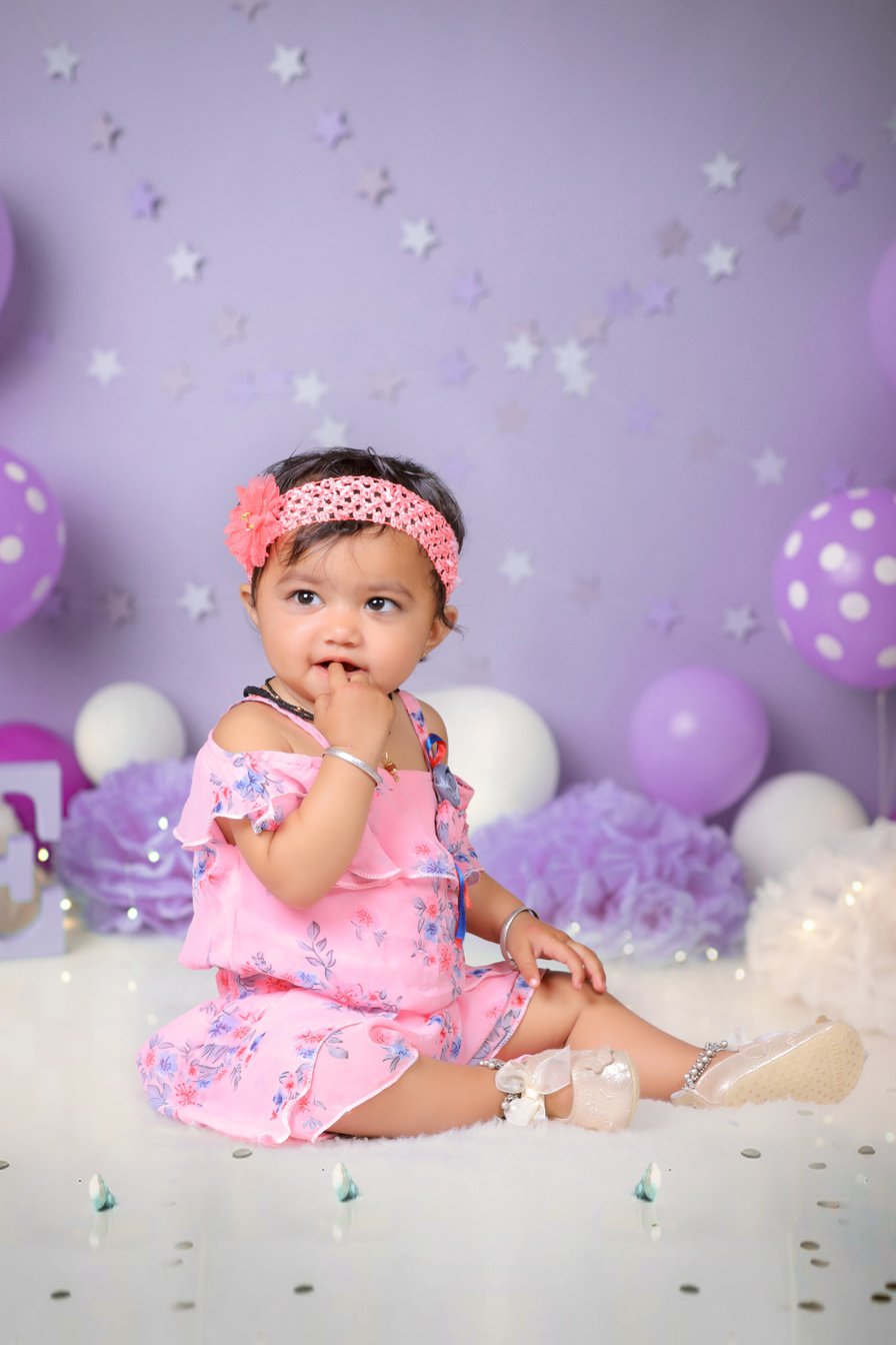 Baby Girl Wearing a Pink Dress Sitting on the Floor